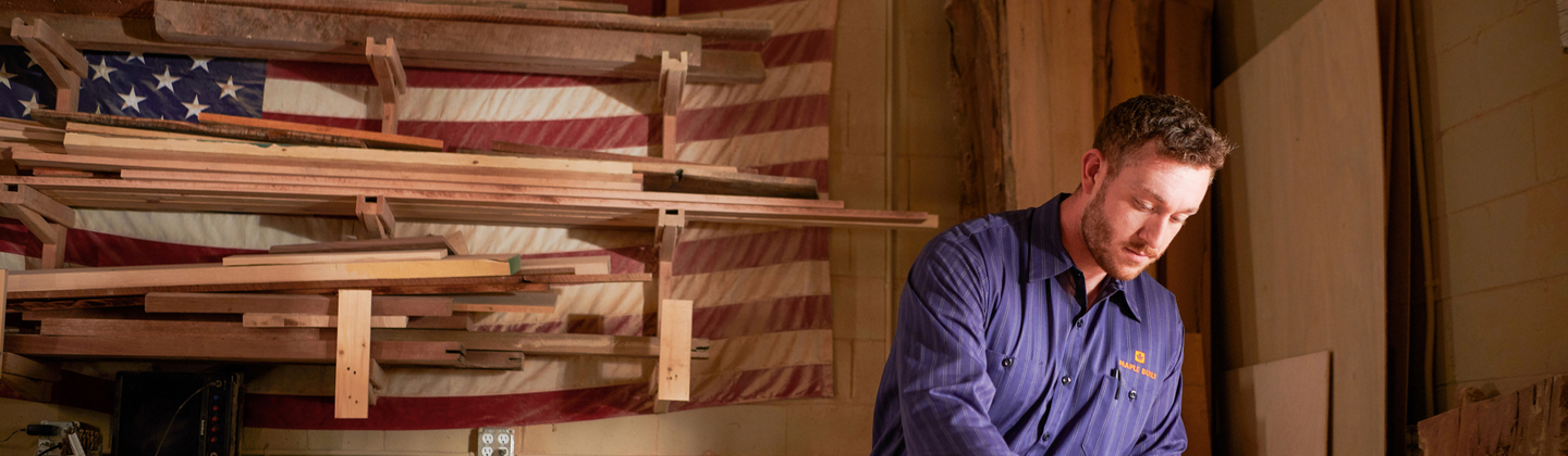 Man wearing a custom workshirt while working in his wood shop Man wearing a custom workshirt while working in his wood shop