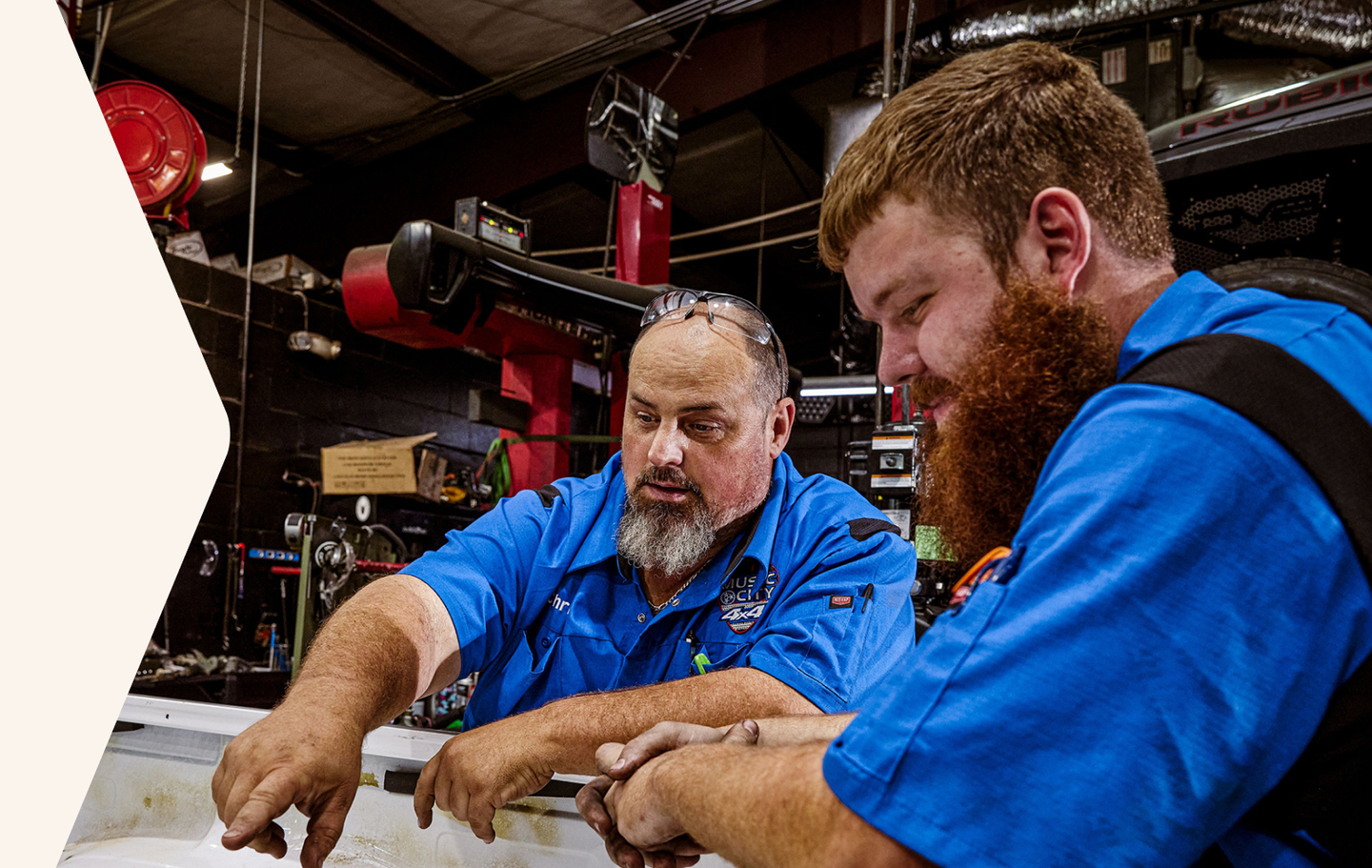 two auto workers wearing customized Red Kap work shirts