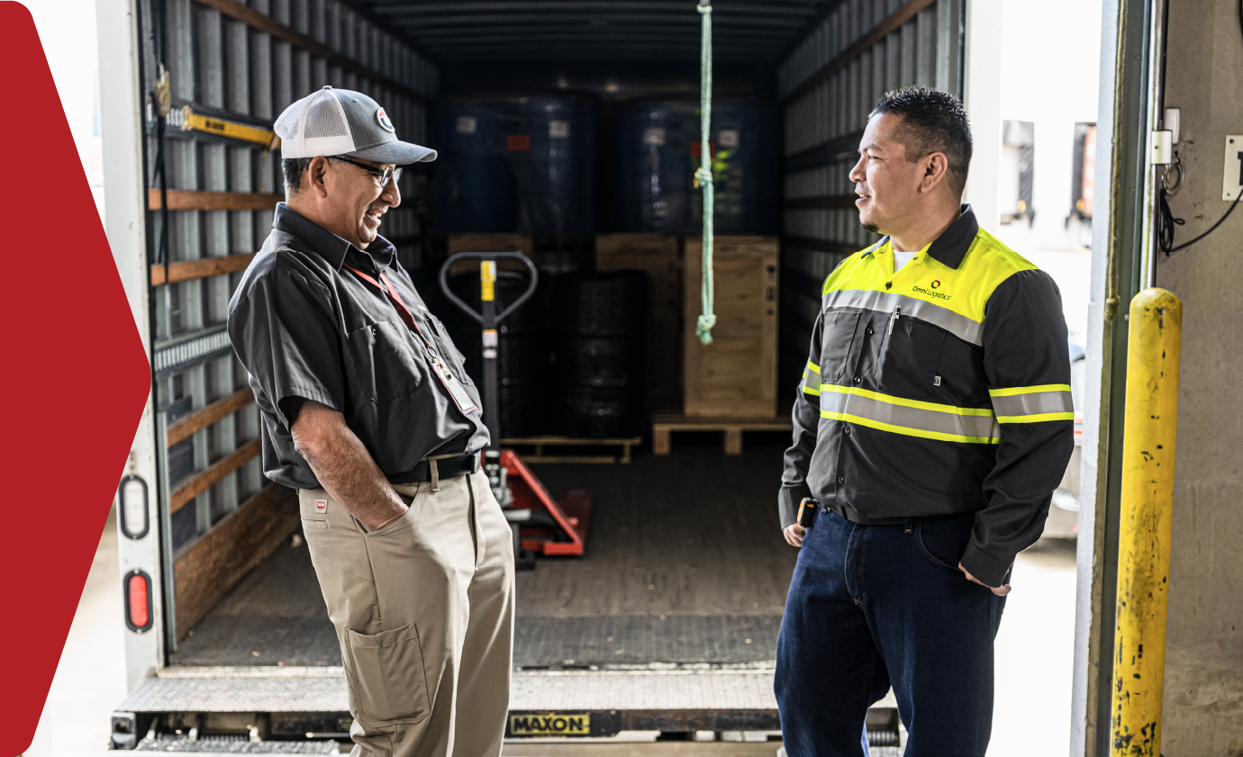 two workers standing behind their open truck bed two workers standing behind their open truck bed